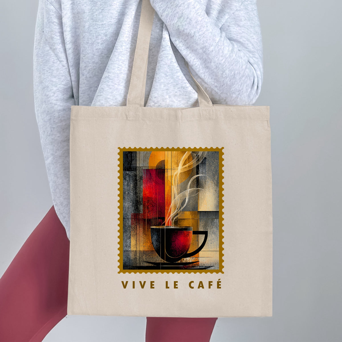 Amber Steam Tote Bag held by a woman, with charcoal cup, flowing cream steam, golden disc and VIVE LE CAFE lettering.