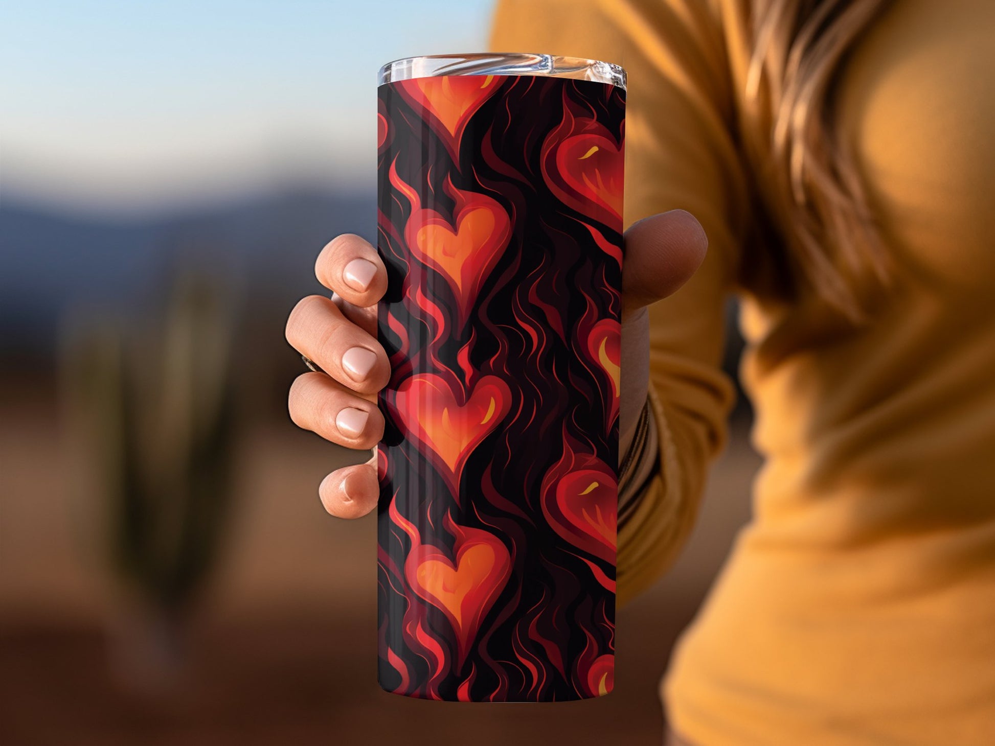 Flaming hearts tumbler in hand, 20oz stainless steel with fiery heart print, ideal for gifting or daily use