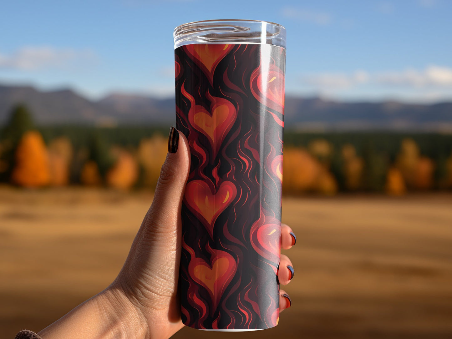 Woman using flaming hearts tumbler, insulated and designed to keep drinks hot or cold with stylish artwork