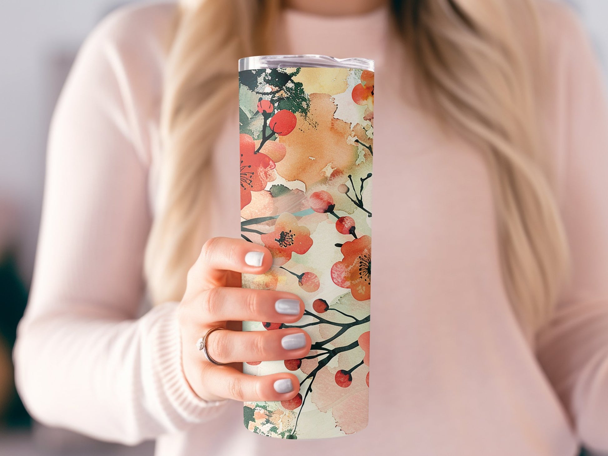 Model holding floral watercolour tumbler, slim 20oz design with metal straw and soft watercolour floral pattern