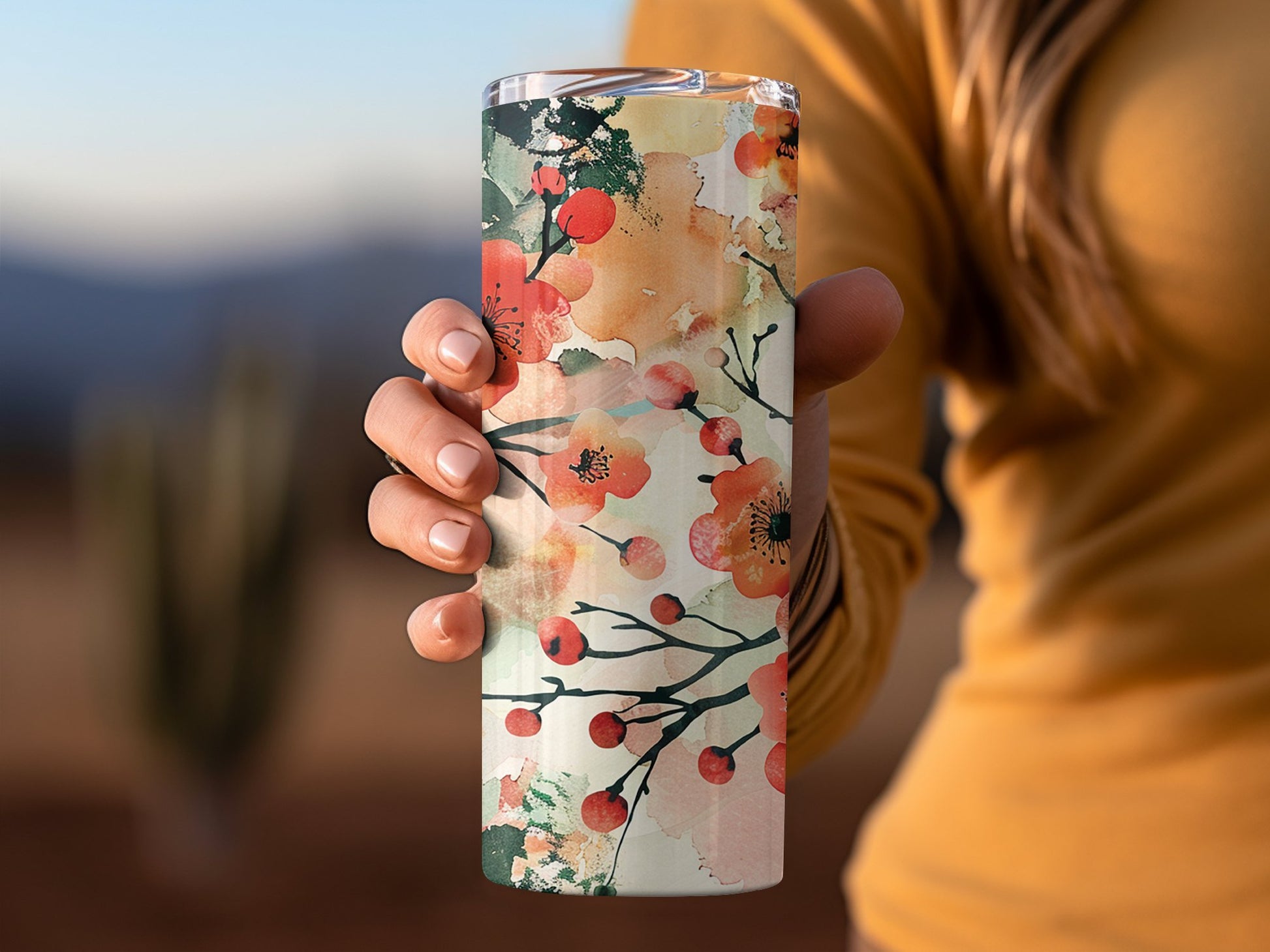 Floral watercolour tumbler in hand, 20oz stainless steel with pastel-coloured flowers and secure clear lid