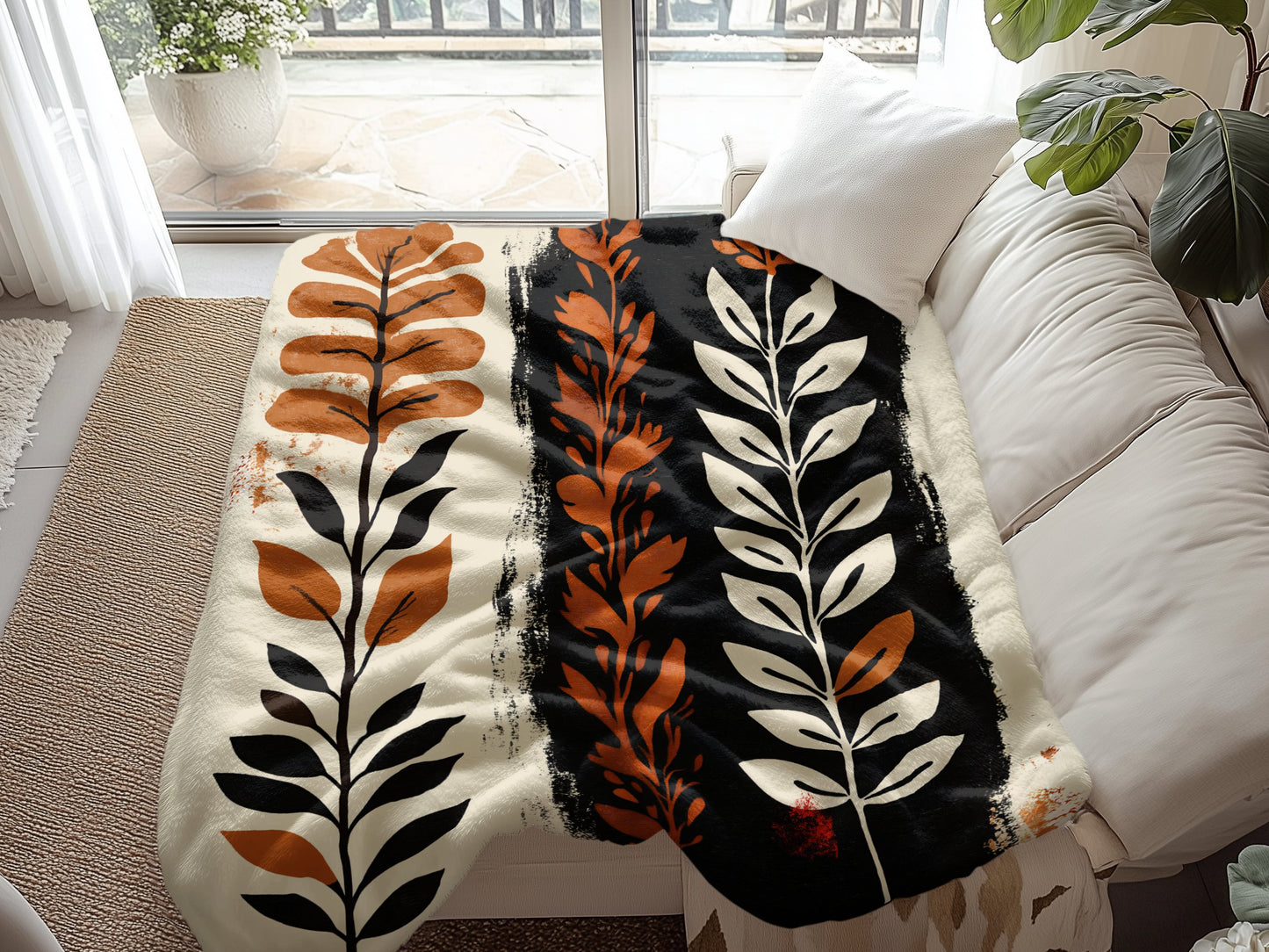 Nomadic Essence Arctic Fleece Blanket draped over a couch, highlighting soft polyester fleece and hemmed edges.