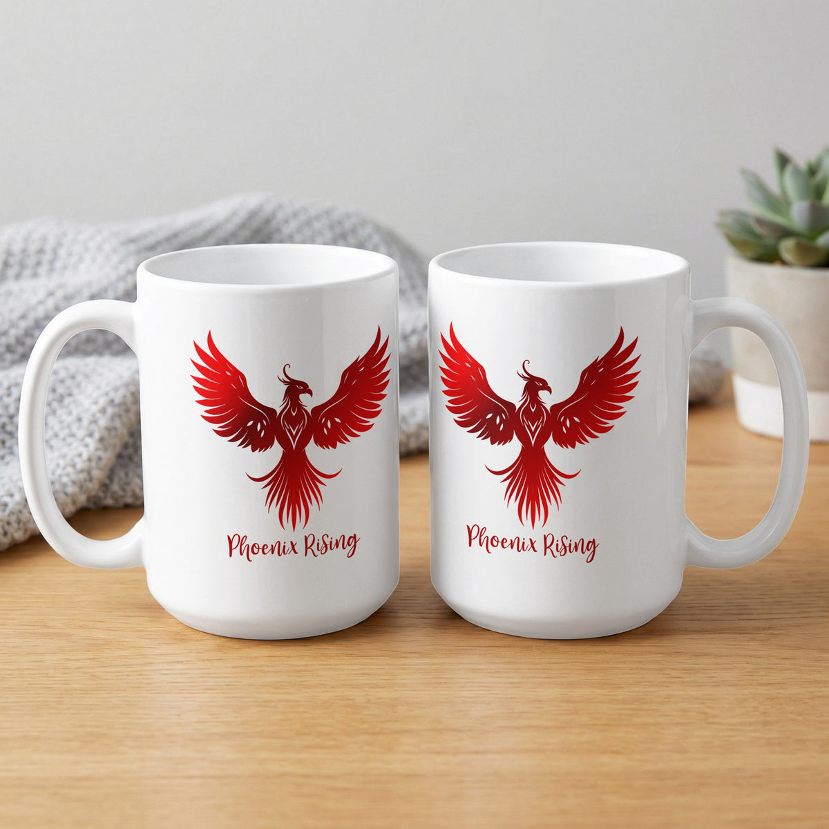 White ceramic Phoenix Rising Mug showing front and back, with red phoenix artwork, subtle feather shading and matching script lettering.
