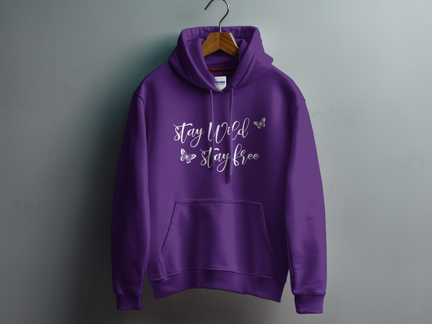 Purple Stay Wild Stay Free Hoodie with a bold design, soft cotton blend, and a cozy pouch pocket for warmth.