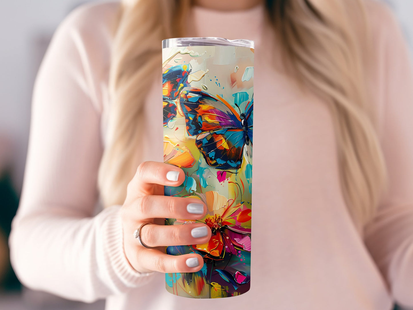 Model holding watercolour butterflies tumbler, slim 20oz design with metal straw and beautiful butterfly artwork