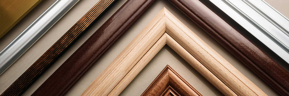 Assorted frame corner samples in different wood and metal finishes displayed on a neutral surface.