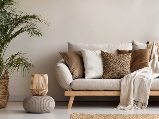 Cream linen sofa styled with tan, white and brown textured cushions in a Japandi-inspired living room.