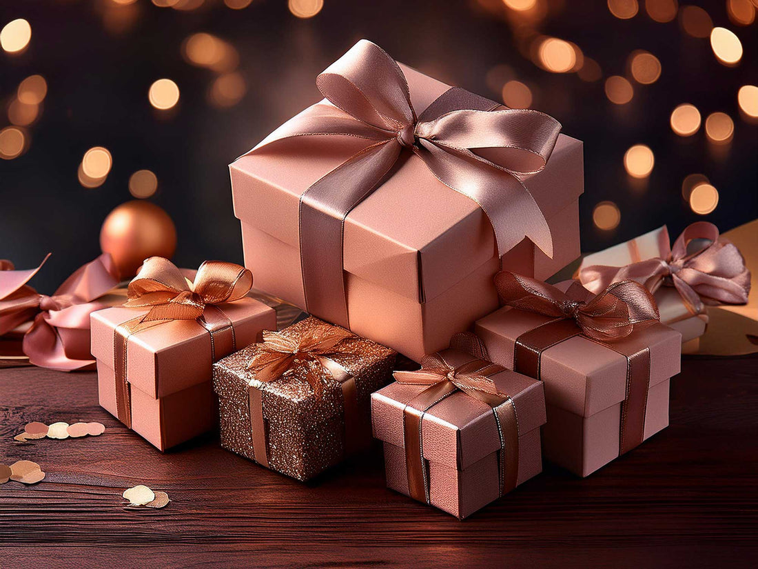 Rose gold and blush gift boxes with satin ribbons displayed against festive bokeh lights.