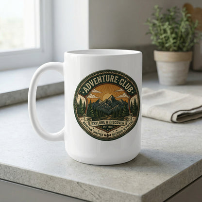Adventure Club 15oz ceramic mug by window featuring radiant sunrise, pine forest and mountain landscape in circular design.