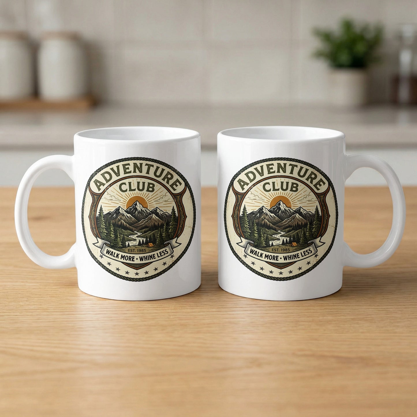 Pair of 11oz Adventure Club mugs arranged to show the identical green wilderness badge design printed on both sides.