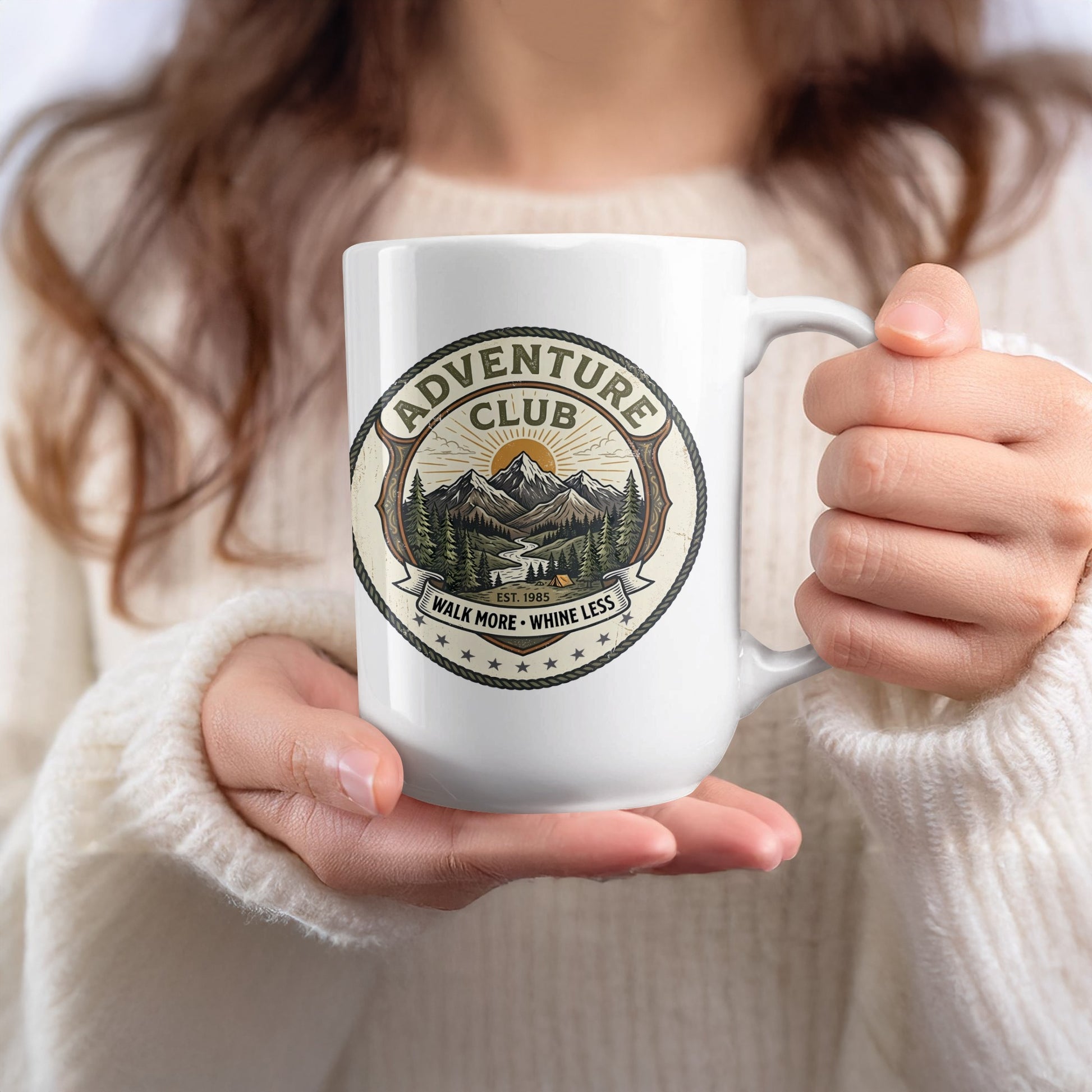 Large 15oz ceramic mug held to show the glossy finish and detailed green forest artwork with a circular banner design.