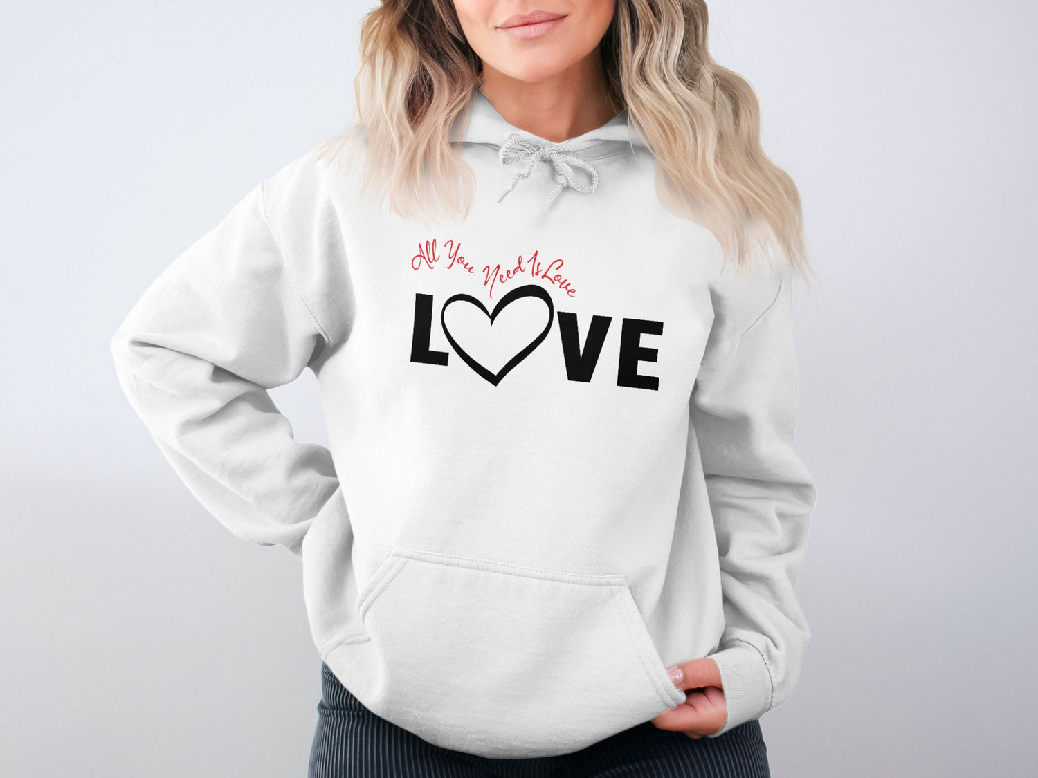 White All You Need Is Love Hoodie featuring script lettering and a heart-shaped Love block typography graphic.
