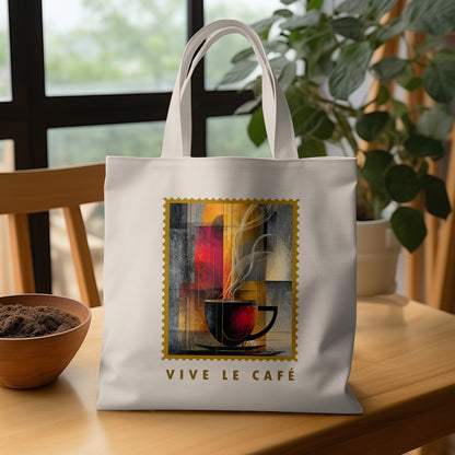 Amber Steam Tote Bag with charcoal cup, amber-golden disc, vertical colour panels and VIVE LE CAFE lettering on wooden table.