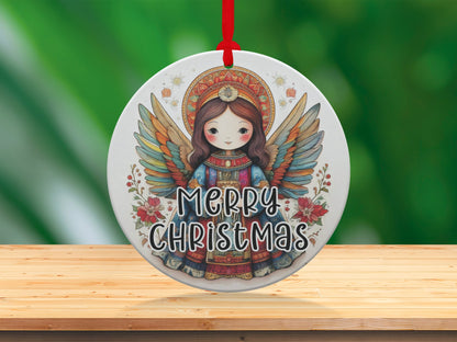 Round Christmas ornament featuring whimsical angel artwork with teal, coral, gold, and amber wing details.