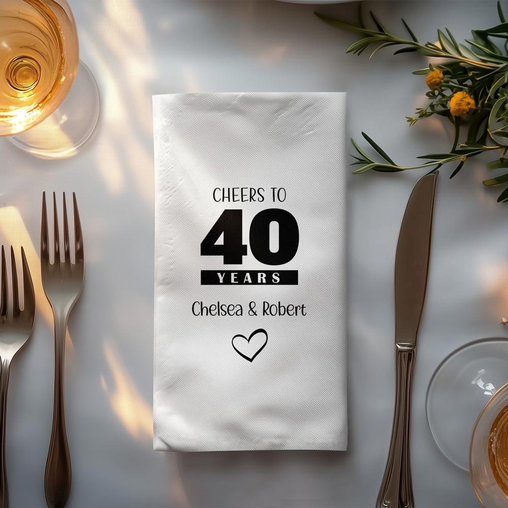 Personalised 40th anniversary white dinner napkin with bold black typographic print on a romantic table setting.