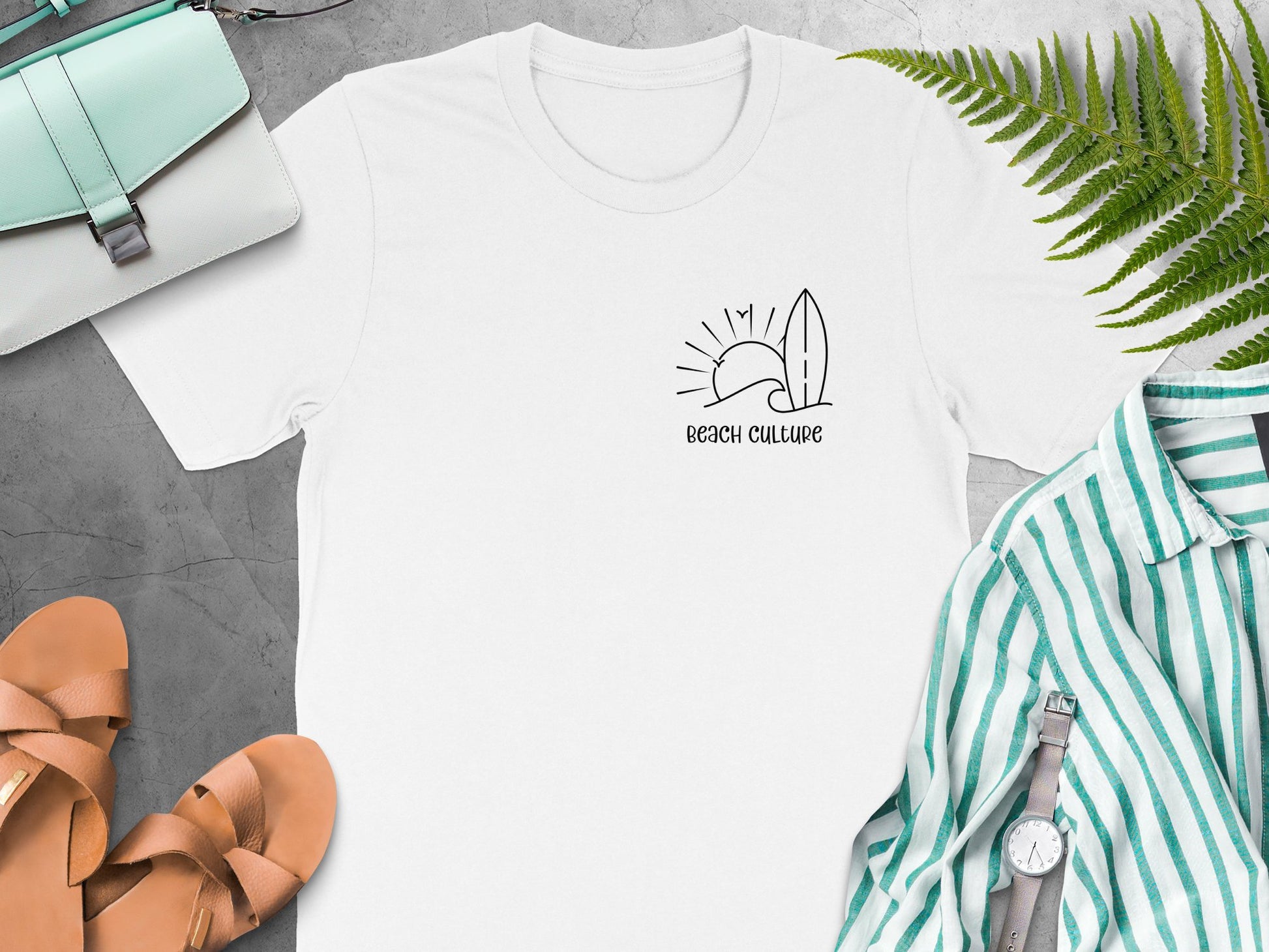 Beach Culture white t‑shirt with minimalist coastal black line‑art of a wave, sun, birds, and surfboard on the left chest.