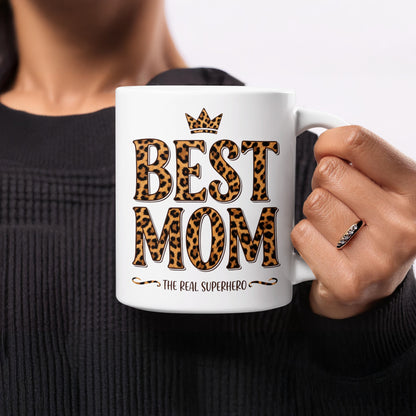 Woman holding 11oz Best Mom The Real Superhero mug, a bold and stylish Mother's Day or birthday gift for moms.