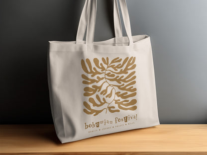 Canvas Bohemian Festival Tote Bag displayed on a sideboard, showing the ochre botanical artwork and bohemian festival lowercase lettering.
