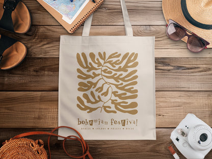 Bohemian Festival Tote Bag featuring a golden-ochre botanical cut-out graphic and playful lettering on natural canvas.