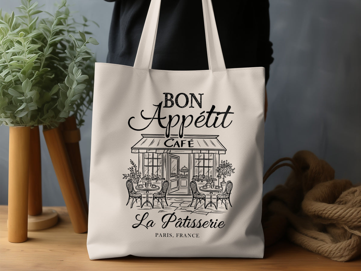 Bon Appétit canvas tote bag design with elegant French script above a detailed Parisian café storefront in black line art.