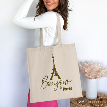 Bonjour de Paris Tote Bag worn over the shoulder, showing the full Eiffel Tower graphic and mixed-font Parisian lettering.