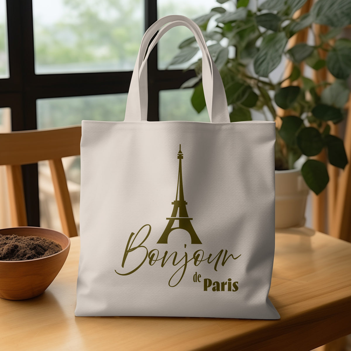 Bonjour de Paris Tote Bag on a wooden table, featuring the Eiffel Tower and contrasting script, serif and bold display typography.
