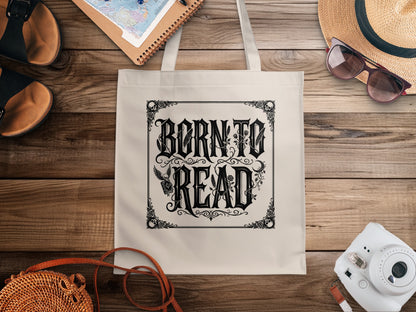 Born to Read Tote Bag featuring ornate blackletter typography, filigree border, corner skulls and winged skull with closed book.