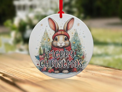 Woodland Christmas ornament featuring a festive rabbit, holly foliage, decorated trees, and Merry Christmas lettering.