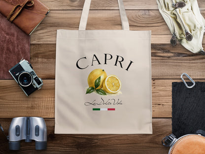 Capri canvas tote bag featuring bold arched CAPRI black lettering, painterly yellow lemons, green leaves and Italian-inspired detailing.