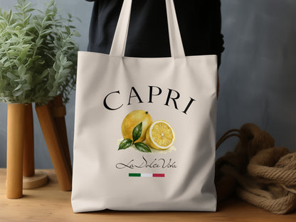 Capri Tote Bag in a lifestyle setting, highlighting the sunny lemon illustration, green foliage and relaxed Mediterranean character.