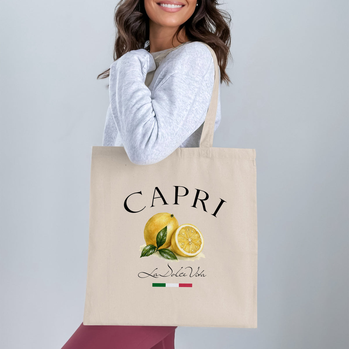Capri Tote Bag worn over the shoulder, showing the full CAPRI graphic, painterly lemons and elegant Italian-inspired artwork.