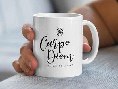 Handheld 11oz Carpe Diem Mug showing flowing black script, Seize the Day text and a small spiral sun icon.