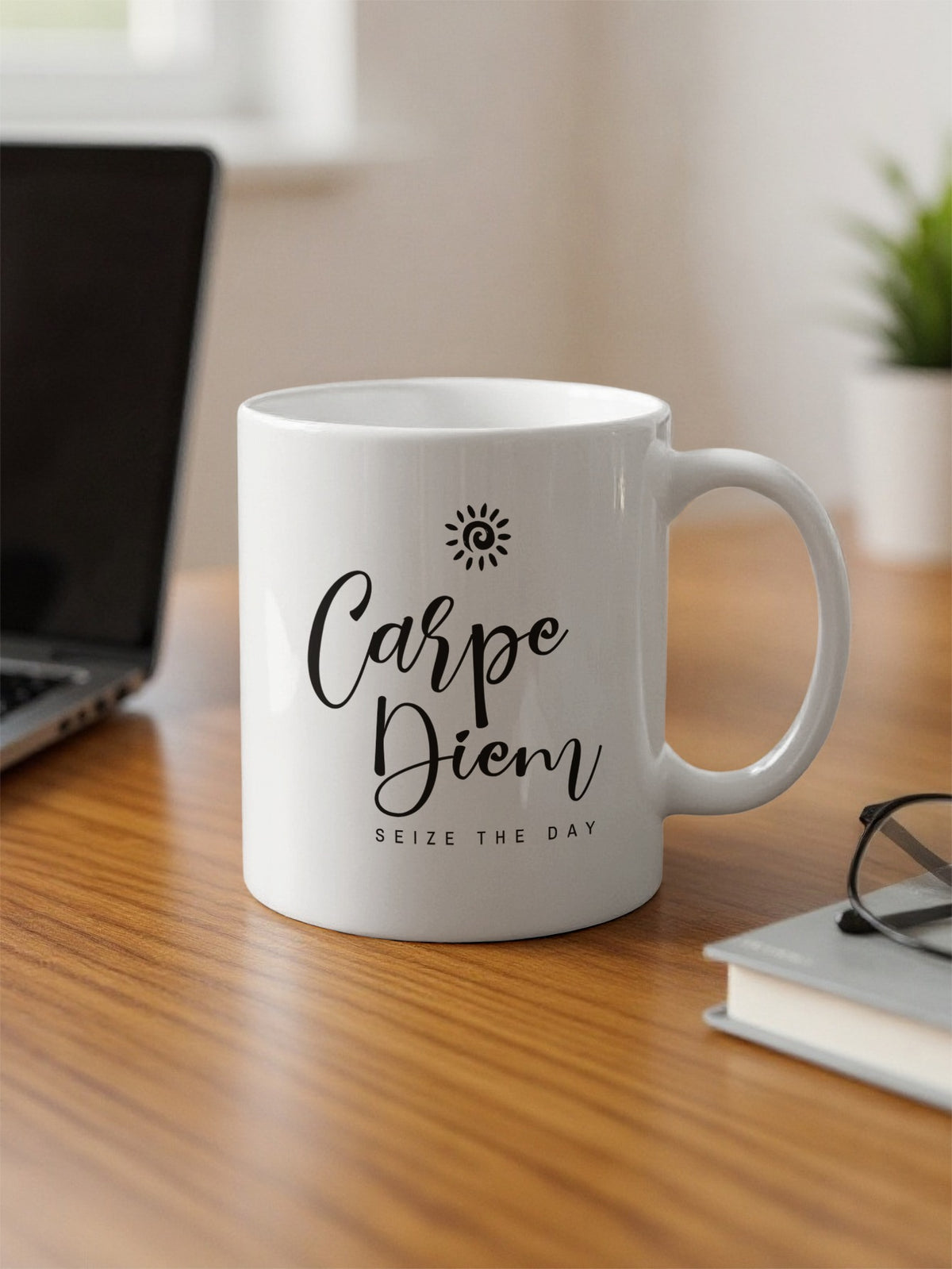 White 11oz Carpe Diem Mug on an office desk featuring black script, Seize the Day lettering and a spiral sun graphic.
