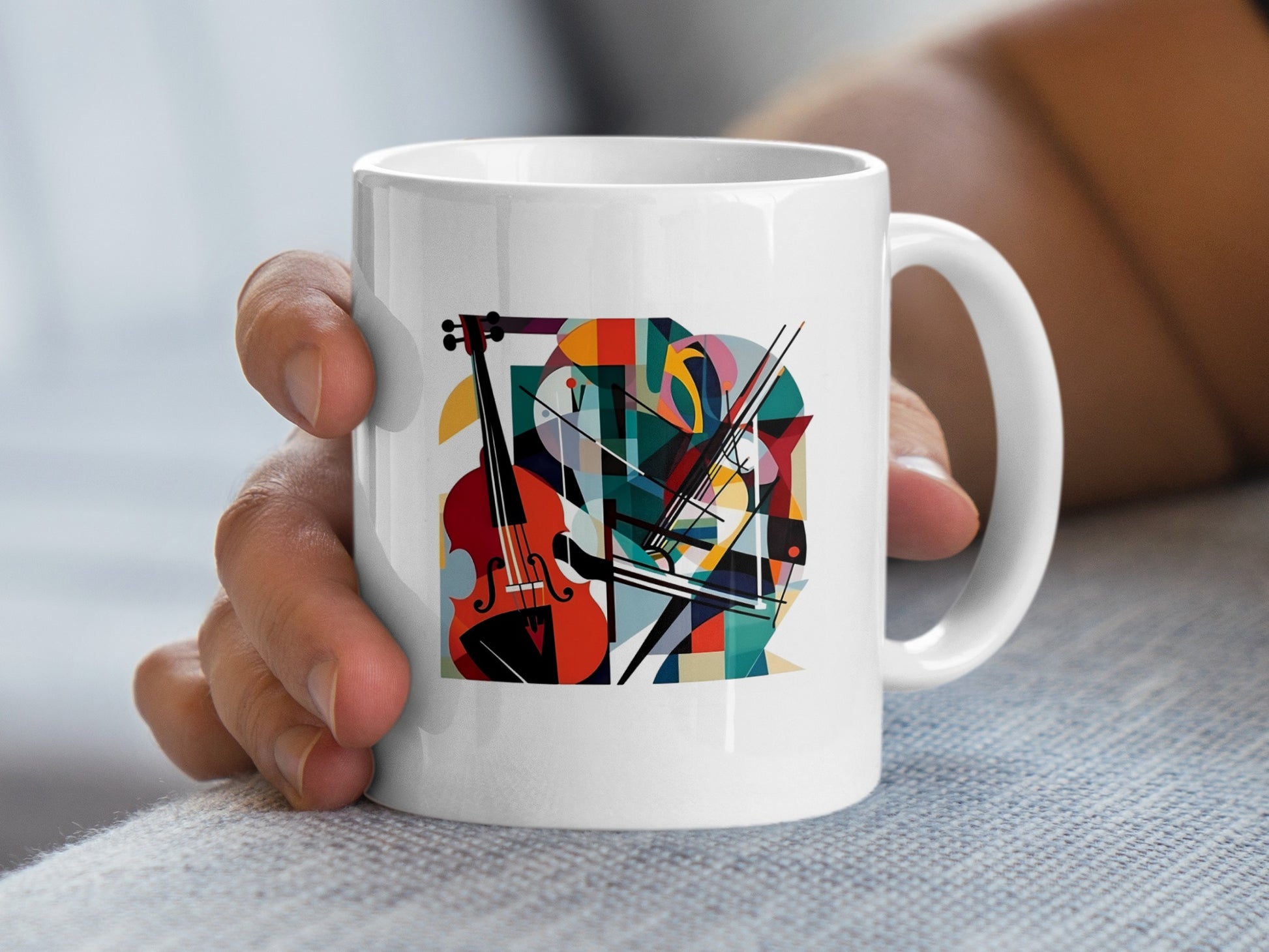 Handheld view showing contemporary music mug artwork with abstract cello design, crossed bows and vibrant geometric shapes.
