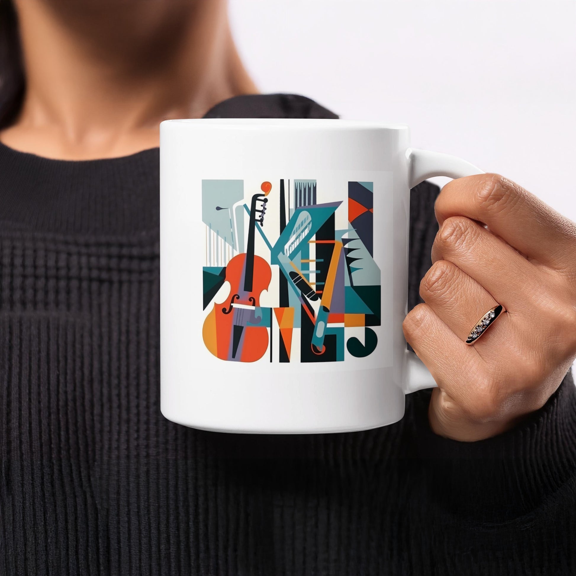 White ceramic coffee mug with mid-century musical artwork featuring cello, treble clef and balanced geometric colour blocks.