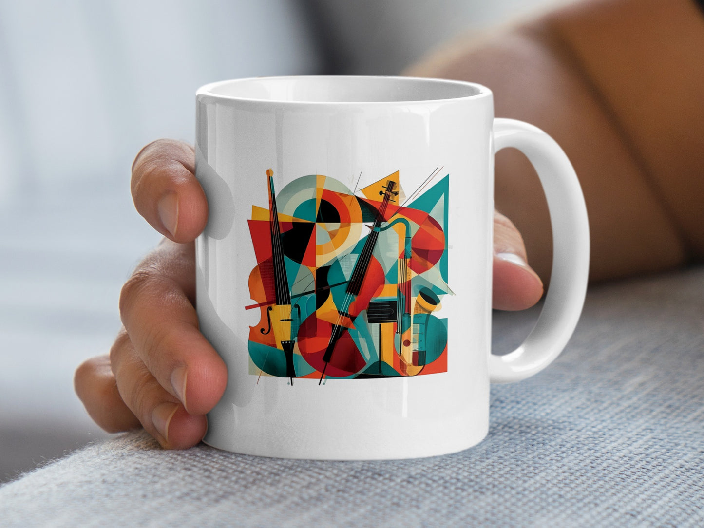 Handheld view showing contemporary music mug artwork with twin cello illustrations, abstract shapes and dynamic bow details.