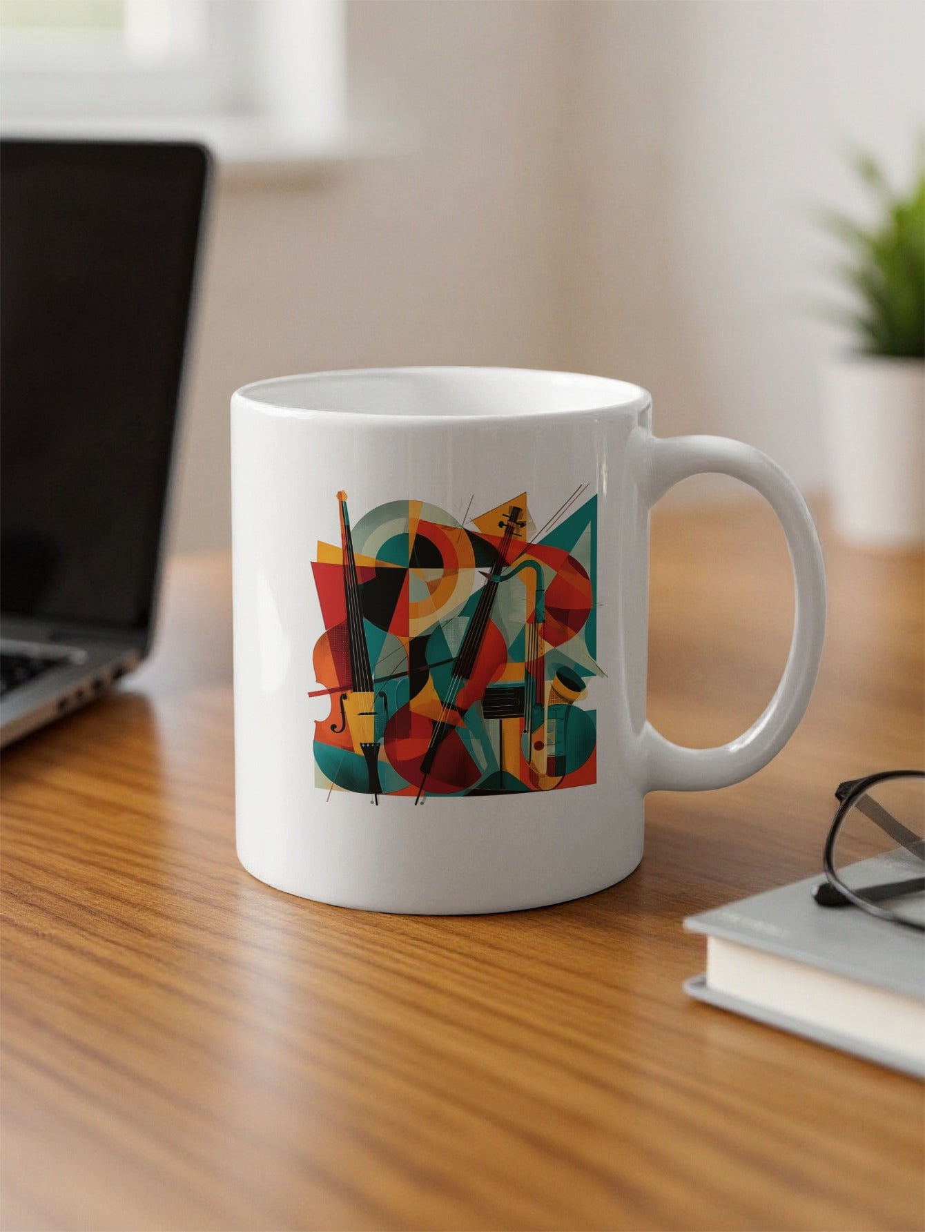 Abstract music illustration on 11oz coffee mug on desk with two cellos, flowing lines and vibrant geometric planes in teal, red and orange.