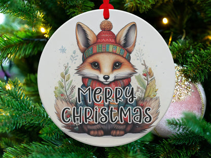 Woodland Christmas aluminium ornament featuring a baby fox in a red knit sweater surrounded by winter greenery.