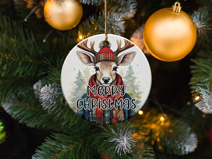 Ceramic Christmas ornament with watercolour deer portrait, denim jacket, red scarf, and snowy woodland backdrop.