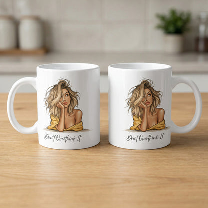 Two 11oz Don't Overthink It Mugs showing front and back with the illustrated portrait, Don't Overthink It black lettering and clean white ceramic.