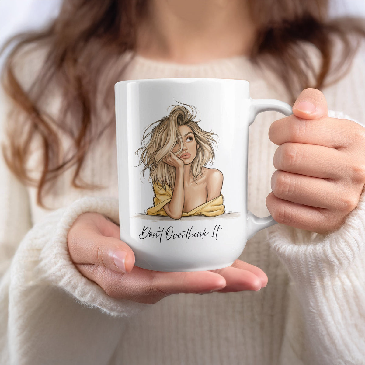 15oz Don't Overthink It Mug held in hand, featuring the tousled blonde hair, upward glance and expressive fashion-sketch artwork.