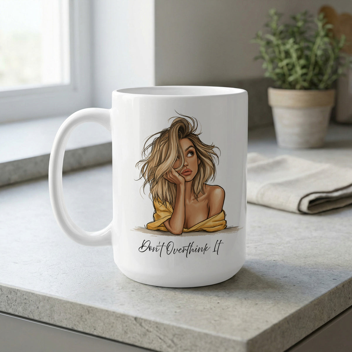 White 15oz Don't Overthink It Mug on a kitchen bench, featuring warm beige, golden and soft yellow portrait artwork.
