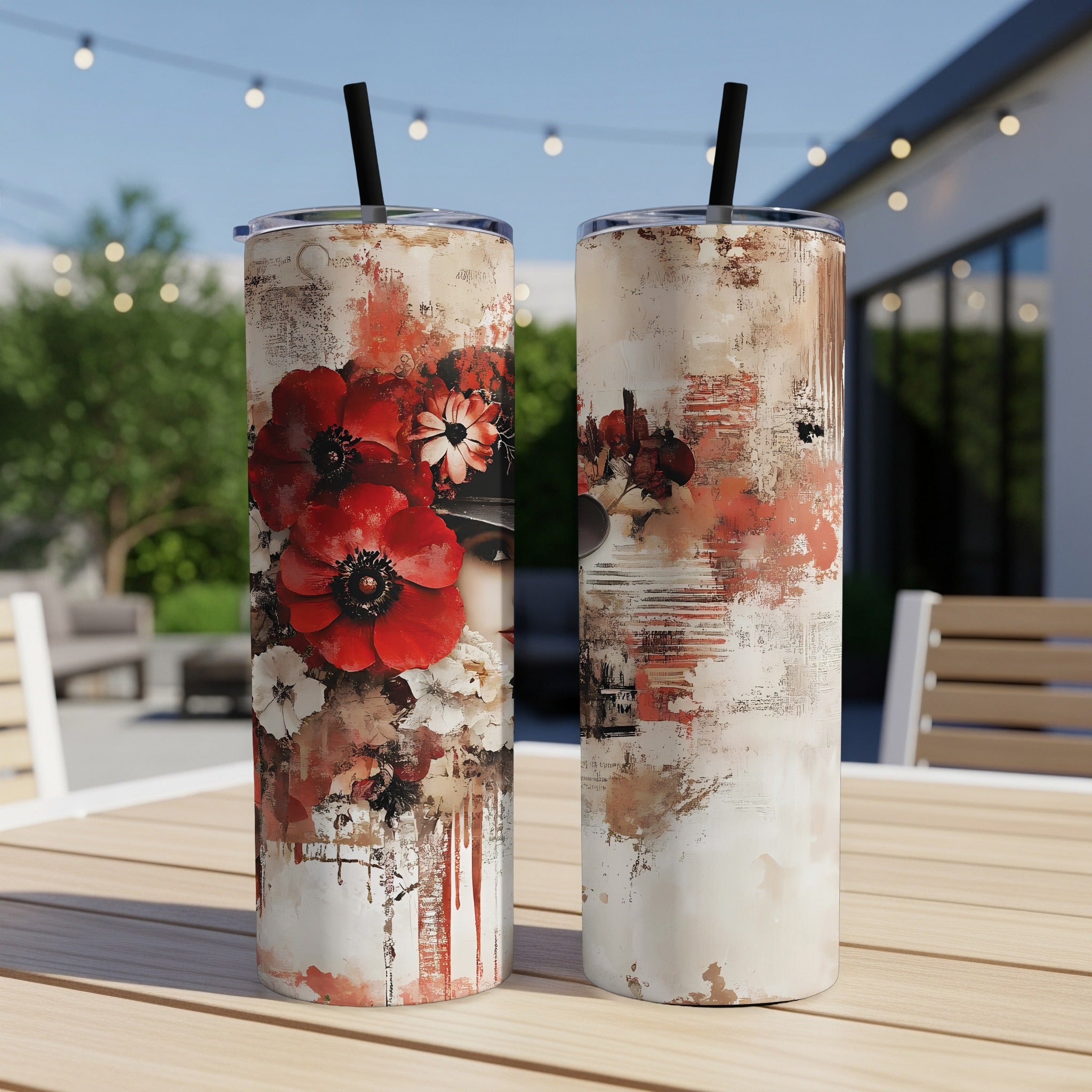 Skinny stainless steel tumbler with distressed red poppy and anemone floral print front and back on an outdoor patio table.