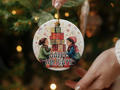 Happy Holidays ornament featuring two children beside stacked Christmas presents topped with a golden star.