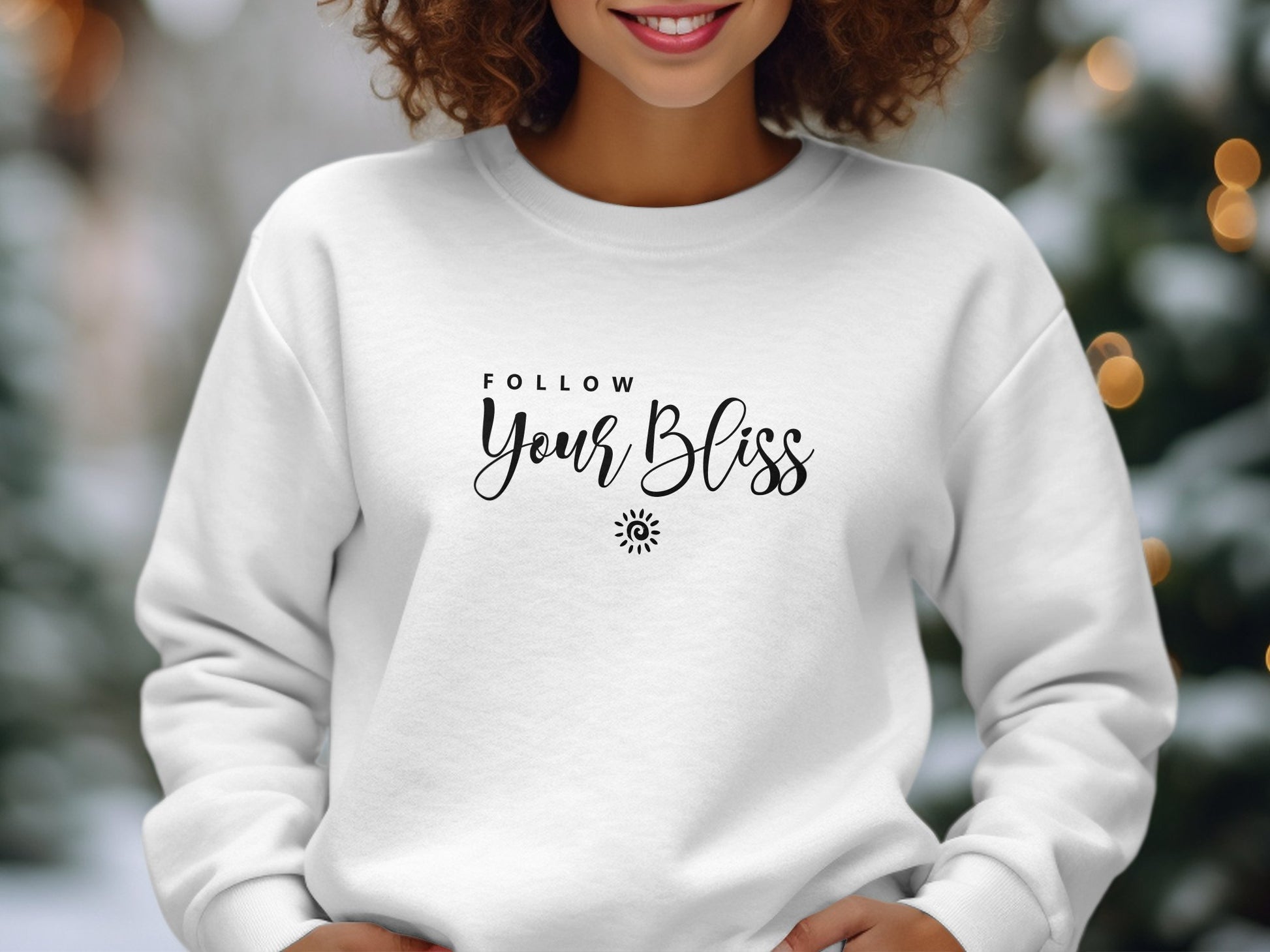 Follow Your Bliss sweatshirt featuring two-line quote typography with spiral sun icon, clean centre-chest print composition.