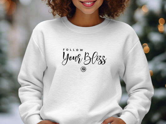 Follow Your Bliss sweatshirt featuring two-line quote typography with spiral sun icon, clean centre-chest print composition.