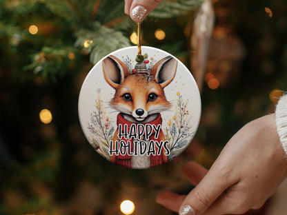 Fox Happy Holidays ceramic ornament featuring a woodland fox with red scarf, holly sprig, and festive berry accents.