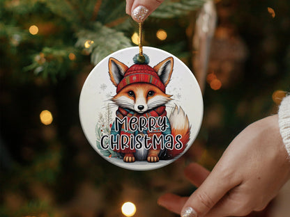 Round holiday ornament showcasing a woodland fox surrounded by holly sprigs, snowflakes, and Merry Christmas text.