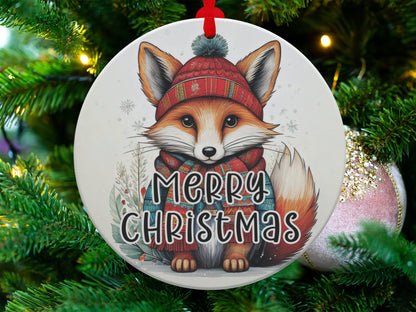 Woodland fox ornament featuring a fluffy fox cub, red hat, plaid scarf, and frosty holiday details.