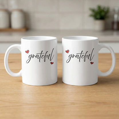 White Grateful Heart Mug showing both sides with matching cursive 'grateful' artwork and two red heart accents.